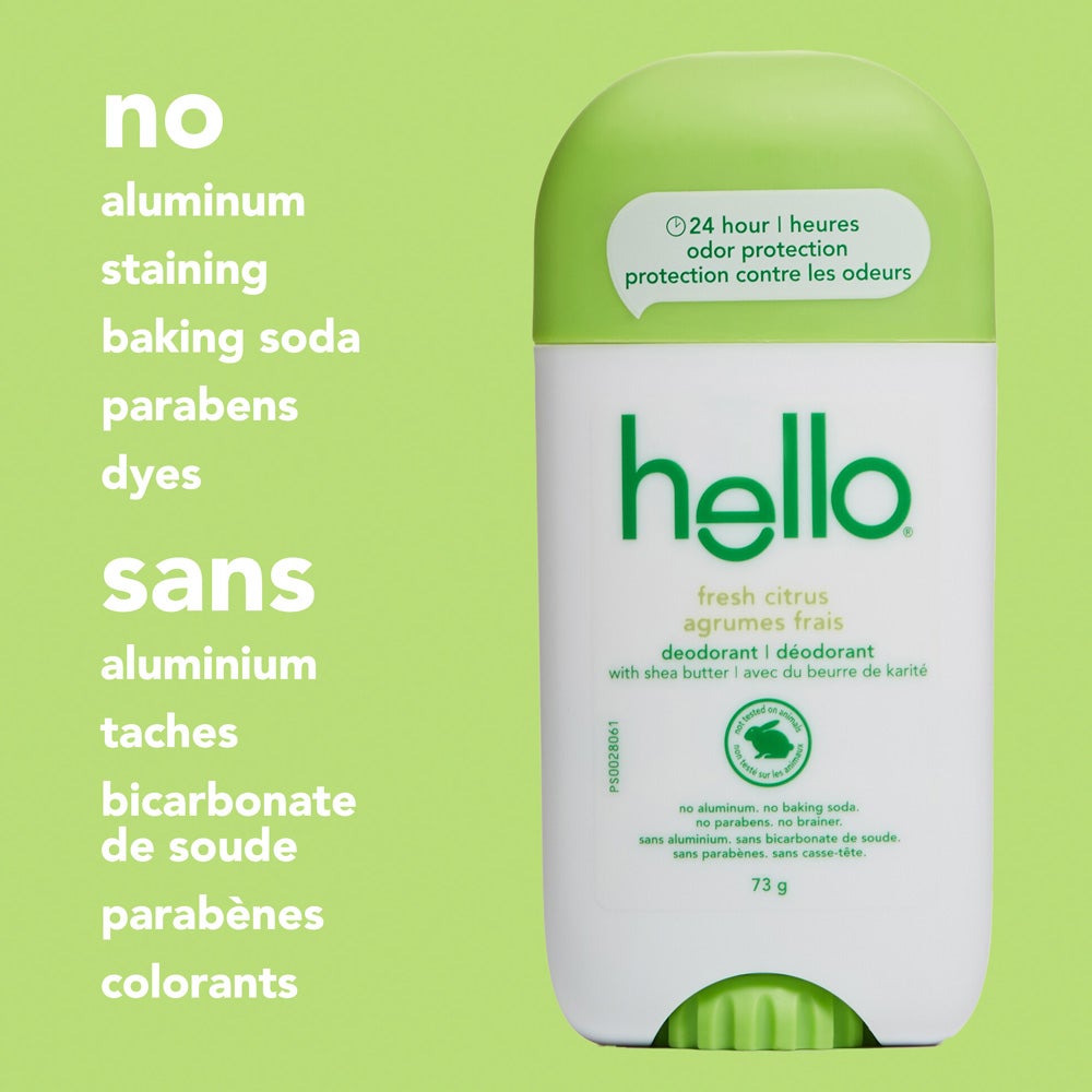 A close-up of a hello fresh citrus  deodorant stick with a green  cap, standing upright on a green  background. The image features text listing product attributes: &quot;no aluminum, staining, baking soda, parabens, dyes.&quot;
