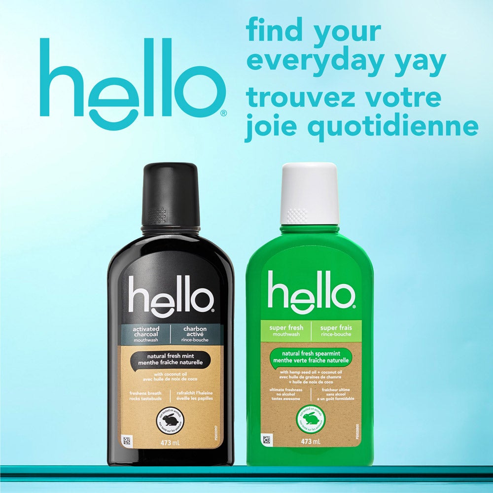Two bottles of hello mouthwash standing side by side against a bright blue background. One bottle is black labeled &quot;activated charcoal&quot; and the other is green labeled &quot;super fresh&quot;. The text above reads, &quot;find your everyday yay&quot; in English and the French translation below. The hello brand logo appears prominently at the top left.