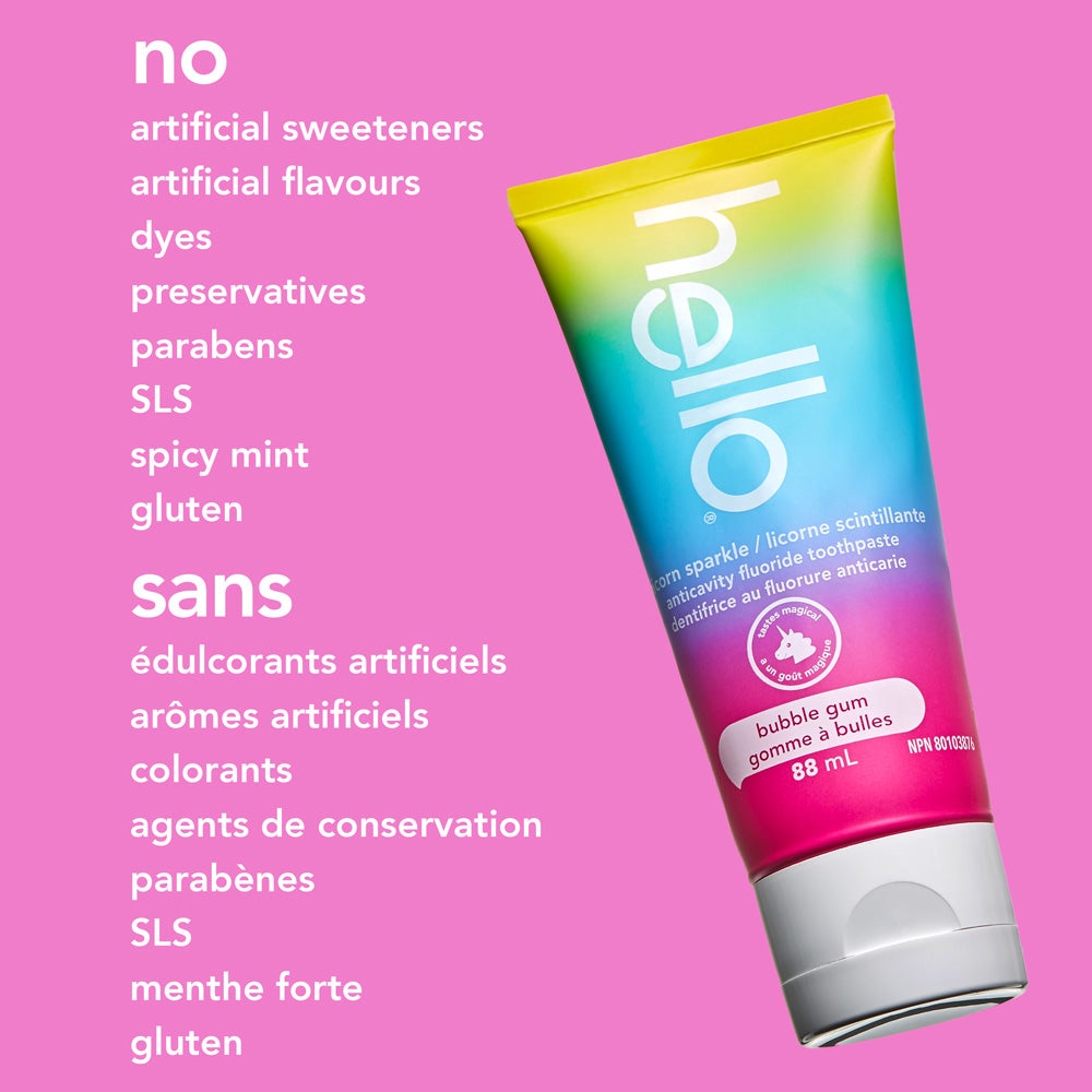 A tube of hello unicorn sparkle bubble gum fluoride toothpaste is shown at an angle on a solid pink background. The text beside it highlights, &quot;no artificial sweeteners, artificial flavours, dyes, preservatives, parabens, SLS, spicy mint, gluten.&quot;