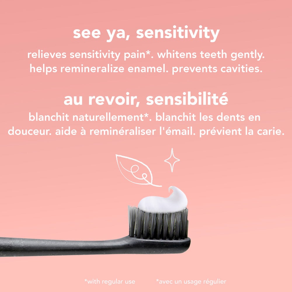 A close-up of a black toothbrush with a dollop of white  See Ya Sensitivity toothpaste is surrounded by fresh mint leaves and pieces of coconut on a pink background. Text highlights &quot;natural mint flavor&quot; and &quot;with coconut oil&quot; in both English and French. toothpaste on its bristles, set against a pink background. Text highlights product benefits: relieves sensitivity pain, whitens teeth gently, helps remineralize enamel, and prevents cavities, in both English and French.