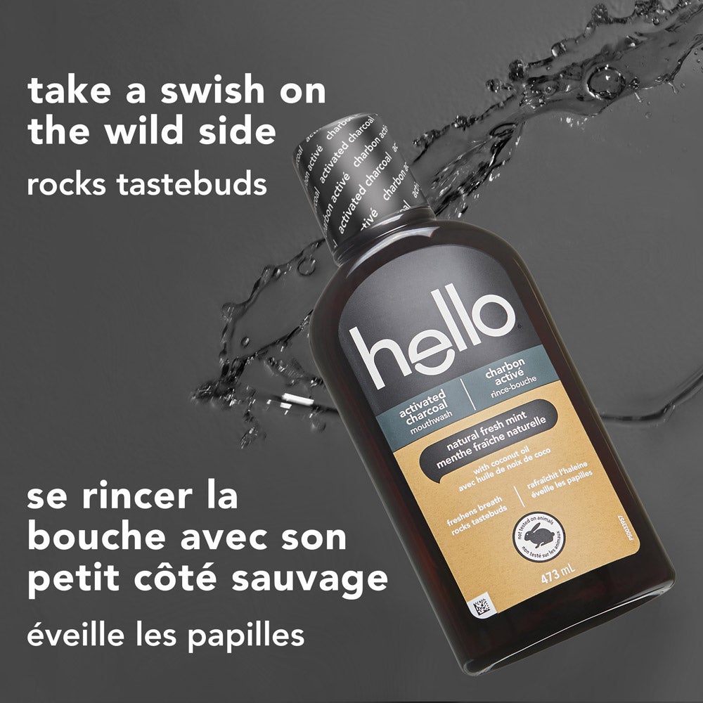 A black bottle of hello activated charcoal mouthwash is tilted on its side with water droplets splashing nearby, set on a dark background. The text above reads: &quot;take a swish on the wild side – rocks tastebuds.&quot;
