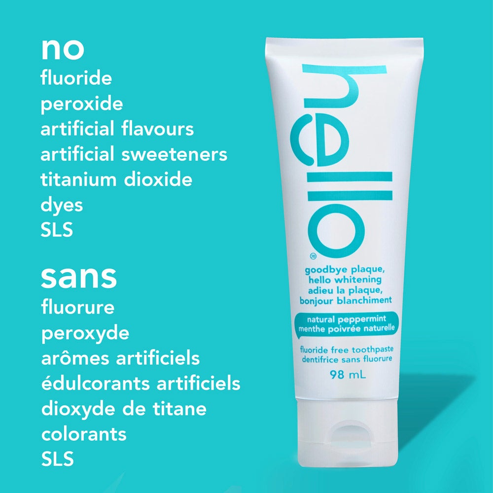 A tube of goodbye plaque hello whitening fluoride free toothpaste in natural peppermint flavor is displayed upright against a turquoise background. Next to the tube, a list reads: &quot;no fluoride, peroxide, artificial flavours, artificial sweeteners, titanium dioxide, dyes, SLS.&quot; The same list appears in French below.
