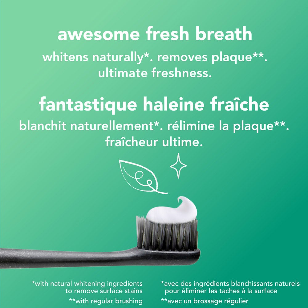 A close-up of a toothbrush with black bristles holding a swirl of white toothpaste, set against a green background. Above the toothbrush, the text reads: &quot;awesome fresh breath – whitens naturally*, removes plaque**, ultimate freshness.&quot; Fine print at the bottom provides additional information about whitening and plaque removal.